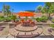 Inviting backyard patio featuring a round brick dining area and lush landscaping at 1145 Glacier Park Ct, Henderson, NV 89052