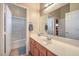 Bright bathroom features a tub-shower with glass doors, updated vanity, and neutral decor at 1145 Glacier Park Ct, Henderson, NV 89052