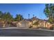 Inviting front exterior of home with three-car garage, desert landscaping and mature trees showcasing curb appeal at 1145 Glacier Park Ct, Henderson, NV 89052