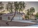 Well-maintained home exterior with a three-car garage, desert landscaping, and mature trees adds curb appeal at 1145 Glacier Park Ct, Henderson, NV 89052