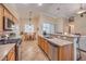 Well-equipped kitchen with stainless steel appliances, granite countertops, and a breakfast bar overlooking the dining area at 1145 Glacier Park Ct, Henderson, NV 89052