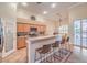 Bright kitchen featuring wooden cabinets, stainless steel appliances, and a breakfast bar overlooking the dining area at 1145 Glacier Park Ct, Henderson, NV 89052