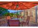Outdoor dining area under a large umbrella, surrounded by lush greenery at 1145 Glacier Park Ct, Henderson, NV 89052