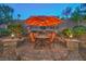 Charming outdoor dining setup featuring a round table with orange umbrella at 1145 Glacier Park Ct, Henderson, NV 89052