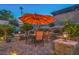 Inviting outdoor dining area with umbrella surrounded by manicured landscaping at 1145 Glacier Park Ct, Henderson, NV 89052