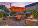 Inviting patio featuring an umbrella-covered table, surrounded by lush greenery and ambient lighting at 1145 Glacier Park Ct, Henderson, NV 89052