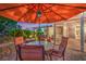 View of patio with table and umbrella, with view of living space through sliding glass door at 1145 Glacier Park Ct, Henderson, NV 89052