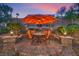 Charming patio area with umbrella-covered dining table and landscaped surroundings, perfect for outdoor relaxation at 1145 Glacier Park Ct, Henderson, NV 89052