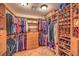 Spacious walk-in closet with custom wood shelving, shoe racks, and ample storage for clothes and accessories at 1145 Glacier Park Ct, Henderson, NV 89052