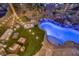 Aerial view of backyard featuring a pool with waterfall, ambient lighting, palm trees and comfortable patio seating at 1246 Diamond Valley St, Henderson, NV 89052