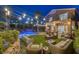 Stunning backyard featuring a rock waterfall pool, ambient lighting, patio, and palm trees, creating an oasis at 1246 Diamond Valley St, Henderson, NV 89052
