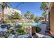 Backyard oasis featuring a pool with rock waterfall, palm trees, ambient lighting, and a comfortable outdoor seating area at 1246 Diamond Valley St, Henderson, NV 89052