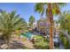 Backyard with pool and waterfall feature, plus patio with furniture and palm trees set in low-maintenance desert landscaping at 1246 Diamond Valley St, Henderson, NV 89052