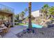 Resort-style backyard with a gorgeous pool, rock waterfall, landscaping, and comfortable patio furniture at 1246 Diamond Valley St, Henderson, NV 89052