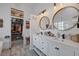 Well-lit bathroom featuring walk-in closet, dual vanity, updated fixtures, and stylish mirrors at 1246 Diamond Valley St, Henderson, NV 89052