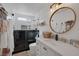 Modern bathroom featuring a glass shower, white vanity with quartz countertop, and round decorative mirror at 1246 Diamond Valley St, Henderson, NV 89052