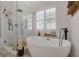 Modern bathroom featuring standalone tub, walk-in shower with white subway tile and shuttered window at 1246 Diamond Valley St, Henderson, NV 89052