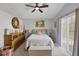 Bright bedroom with neutral walls, ceiling fan, slider to balcony and rustic wood dresser at 1246 Diamond Valley St, Henderson, NV 89052