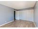 This bedroom features wood-look floors, a large closet, neutral gray walls, and a white door at 1372 Lorilyn Ave # 3, Las Vegas, NV 89119