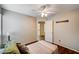 A simple bedroom features a ceiling fan, wood floors and a comfortably sized bed at 1968 Evening Glow Dr, Las Vegas, NV 89134