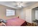 Cozy bedroom featuring a ceiling fan, window with blinds, and convenient access to the bathroom at 1968 Evening Glow Dr, Las Vegas, NV 89134