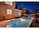 Nighttime view of a private pool and jacuzzi, beautifully illuminated within a serene backyard setting at 1968 Evening Glow Dr, Las Vegas, NV 89134