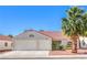 Charming single-story home featuring a two-car garage and a tile roof, surrounded by low-maintenance landscaping at 2109 Mountain Sunset Ave, North Las Vegas, NV 89031