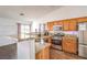 Well-lit kitchen featuring wood cabinets, granite countertops, stainless steel appliances and wood-look floors at 2109 Mountain Sunset Ave, North Las Vegas, NV 89031