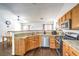 A kitchen view with stainless steel appliances, stone countertops, wood cabinets, and tile backsplash at 2109 Mountain Sunset Ave, North Las Vegas, NV 89031