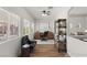Staged office features desk, shelving and reading chair with wood floors, white walls, and a ceiling fan at 215 Sunlight Peak St, Henderson, NV 89012