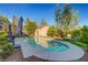 Backyard pool with outdoor seating area, lush landscaping, and a charming patio with shade for outdoor enjoyment at 2150 Maple Heights Ct, Henderson, NV 89052