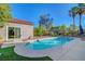 Backyard pool with manicured yard and rock landscaping, featuring a covered patio area with seating at 2150 Maple Heights Ct, Henderson, NV 89052