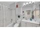 Bright bathroom with white vanity, shower/tub combo, and decorative wall accents at 2150 Maple Heights Ct, Henderson, NV 89052