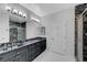 Bathroom with gray vanity, marble countertop, dual sinks, and glass-enclosed shower at 2150 Maple Heights Ct, Henderson, NV 89052