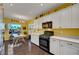Inviting kitchen with white cabinets, black appliances, and a dining area bathed in natural light, creating a warm atmosphere at 2150 Maple Heights Ct, Henderson, NV 89052