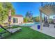Inviting backyard pool area features lounge chairs, lush landscaping, and a charming pergola for relaxing outdoors at 2150 Maple Heights Ct, Henderson, NV 89052