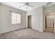 Bright bedroom features neutral carpet, ceiling fan, closet and doorway to bathroom and laundry area at 2508 Chasma Dr, Henderson, NV 89044