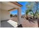 Covered patio with desert landscaping, including palm trees and rocks, offering a relaxing outdoor space at 2508 Chasma Dr, Henderson, NV 89044