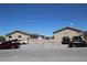 Desert home featuring a beige exterior, gravel landscaping, and ample parking space in front of the property at 2520 E Ambush St, Pahrump, NV 89048
