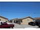Desert home with tan stucco, gravel landscaping, and dark colored vehicles in front of the property at 2520 E Ambush St, Pahrump, NV 89048