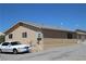 Desert home with tan stucco, gravel landscaping, and a small garden area at 2520 E Ambush St, Pahrump, NV 89048