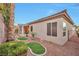 Private backyard featuring meticulous landscaping, a covered patio, and a stucco perimeter wall at 2585 Portsmouth Creek Ave, Henderson, NV 89052