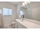Bright bathroom featuring a toilet, a sink, a large mirror and natural light from the window at 326 Zenith Crest St, Henderson, NV 89015