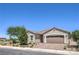 Attractive single-story home with a desert landscape, paver driveway, and a two car garage at 326 Zenith Crest St, Henderson, NV 89015