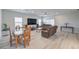 Bright, open-concept living room featuring a modern sofa, dining table, and light wood flooring at 326 Zenith Crest St, Henderson, NV 89015