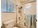 Bathroom with a bathtub, glass door, and tiled walls, complemented by a window with blinds at 333 Abbington St, Henderson, NV 89074