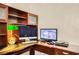 A home office area with built-in wooden cabinets and a desk, featuring dual computer monitors at 333 Abbington St, Henderson, NV 89074