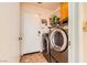 Laundry room with modern front-load washer and dryer and tile flooring near the backdoor at 333 Abbington St, Henderson, NV 89074