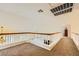 Bright and airy loft space with carpeting and a wood and white railing overlooking the floor below at 333 Abbington St, Henderson, NV 89074