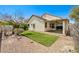 The backyard is low maintenance with a covered patio, a patch of green grass, and rock landscaping at 3609 Blue Pimpernel Ave, North Las Vegas, NV 89081